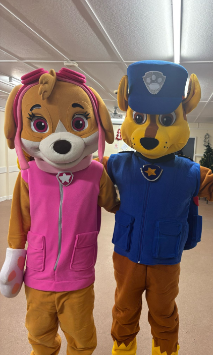 A man and a woman in paw patrol costumes are standing next to each other.