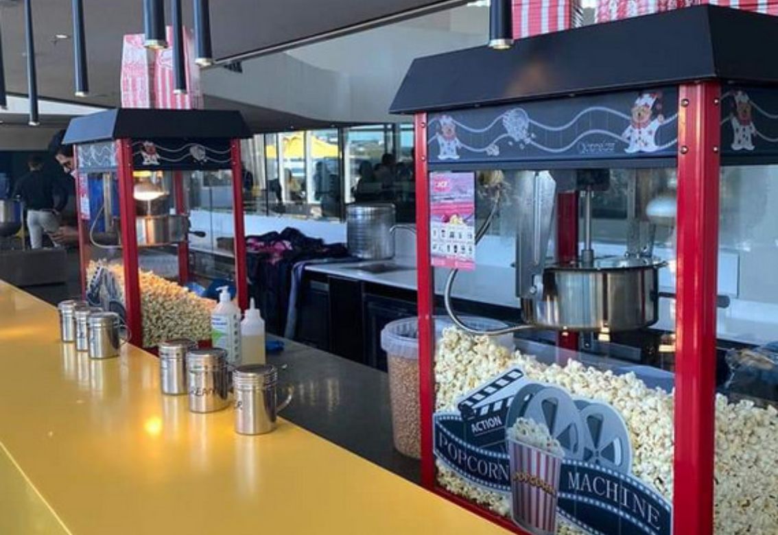 A popcorn machine is sitting on a counter in a restaurant.