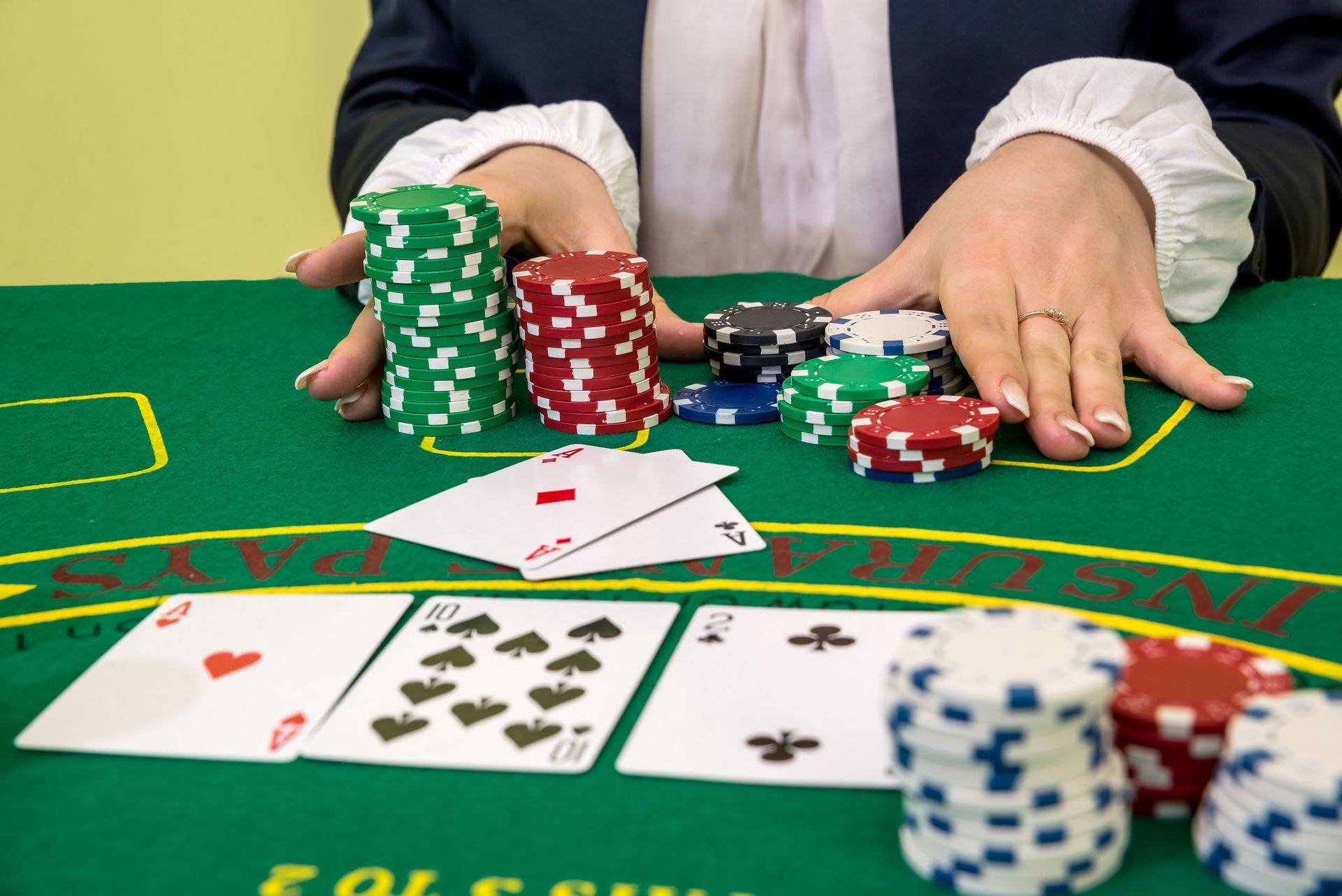 A baccarat table with playing cards and colorful casino chips being handled during gameplay.
