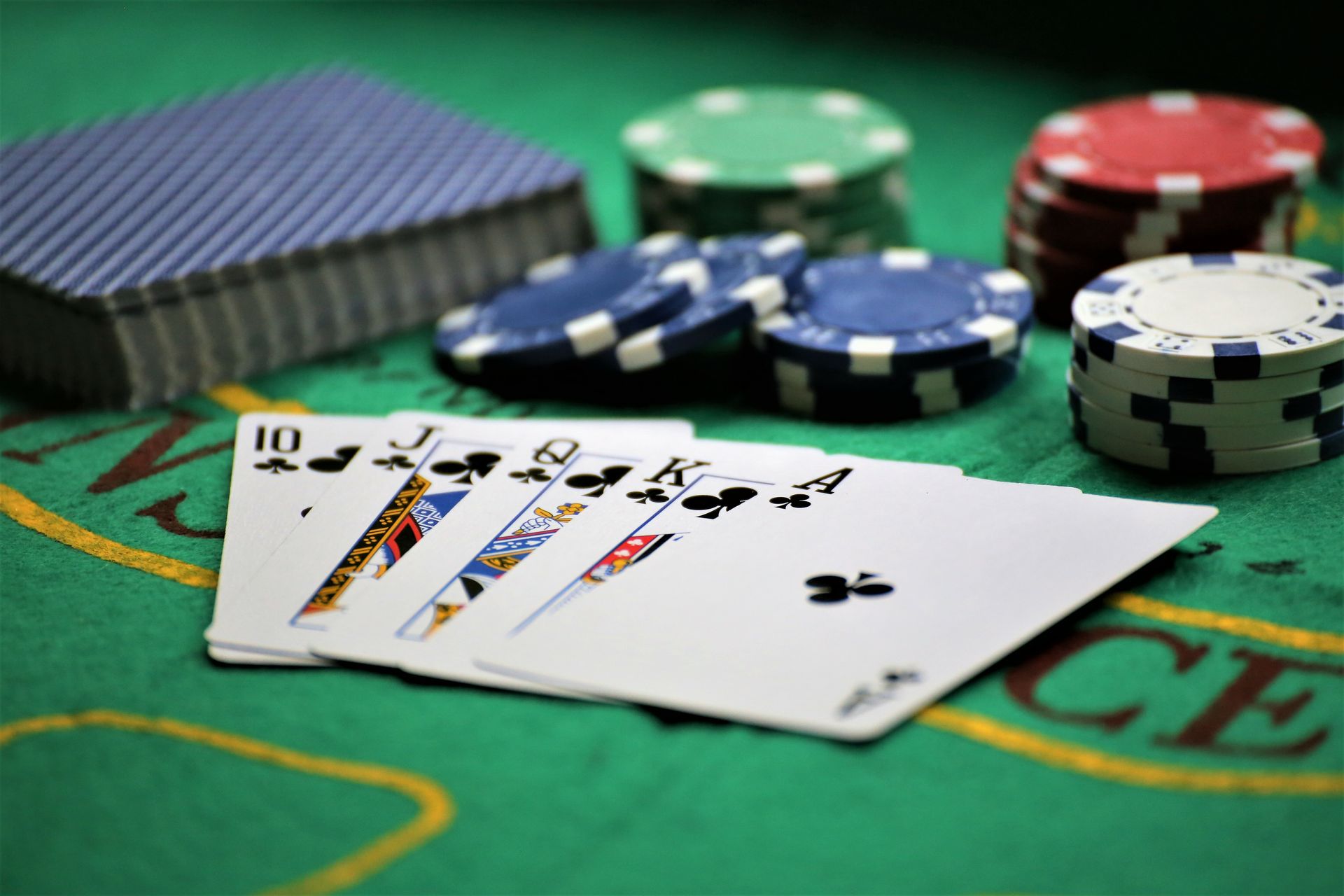 Poker hand with cards and colorful chips scattered across a green casino table.