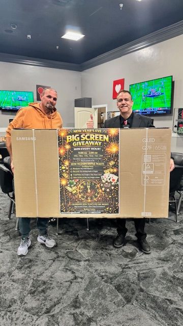 Two men holding a large cardboard box with a 