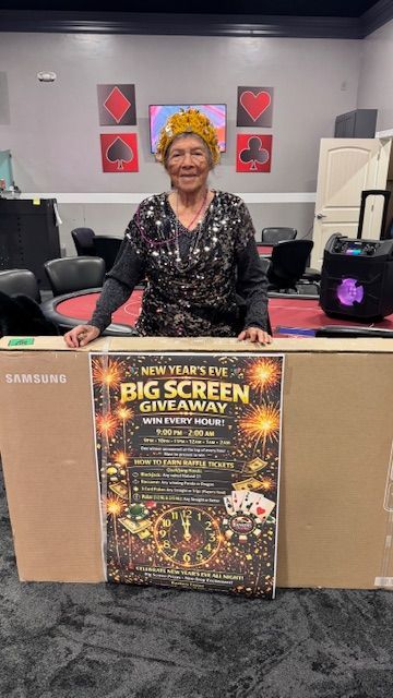 Woman wearing crown stands behind giveaway sign next to a large Samsung TV box in a casino.