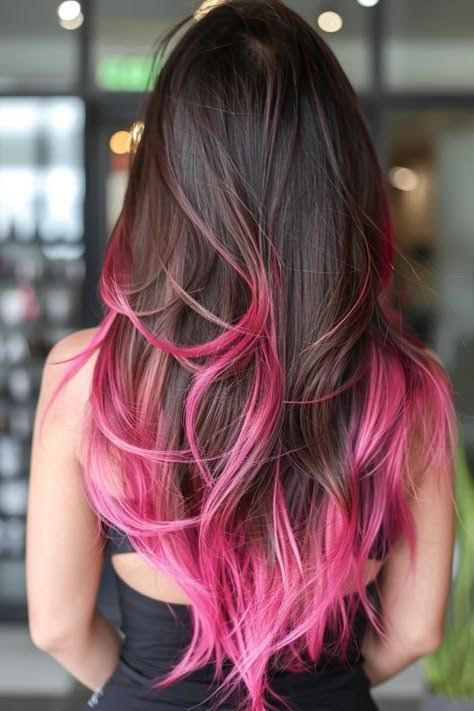 Woman with dark brown hair, layered, with vibrant pink dip-dye.