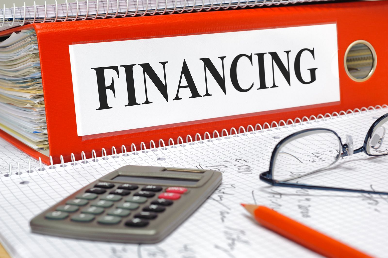 A red binder with the word financing on it