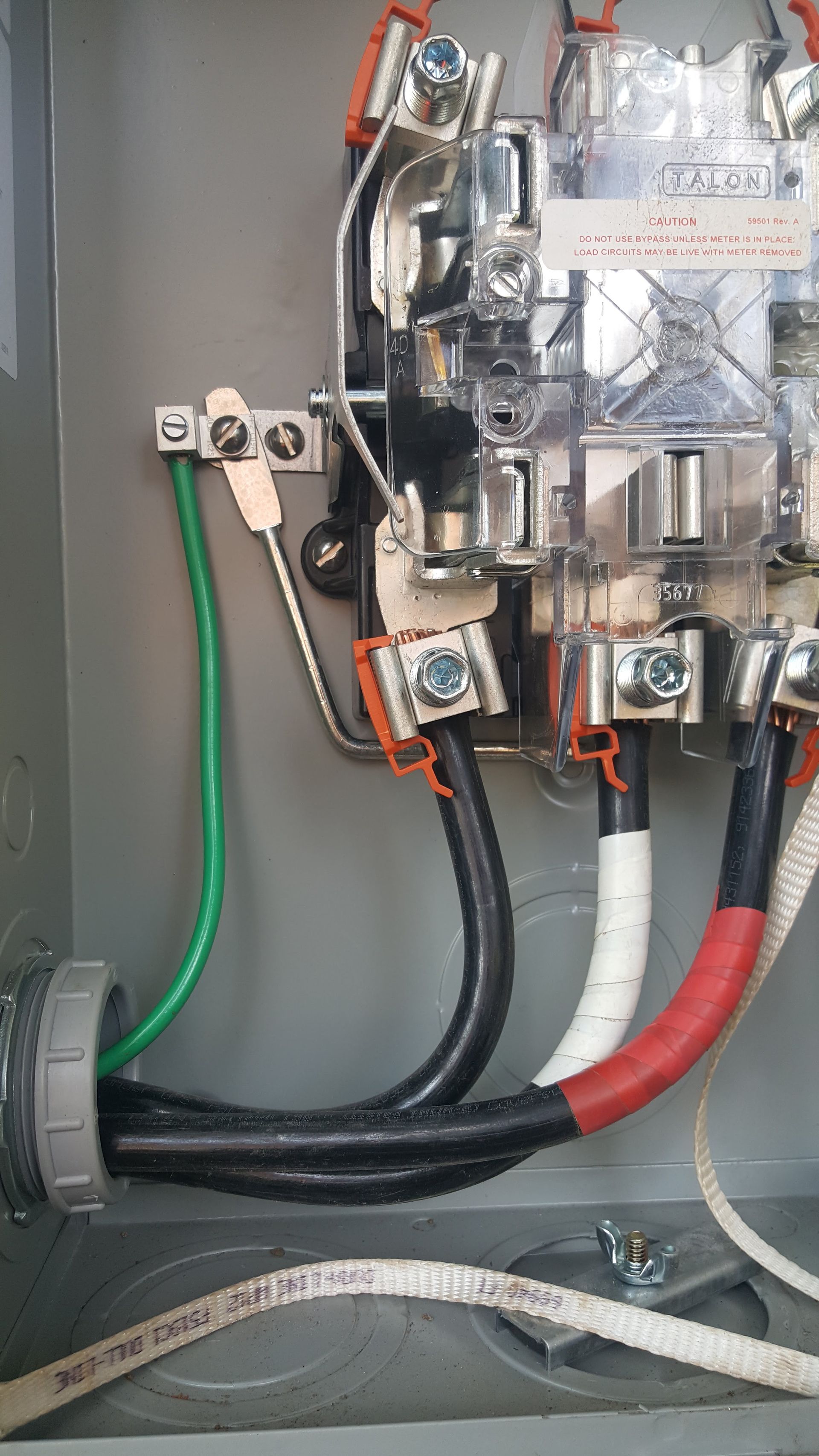 Electrical wiring in a gray metal box, with black, white, and red wires connected to a circuit breaker.