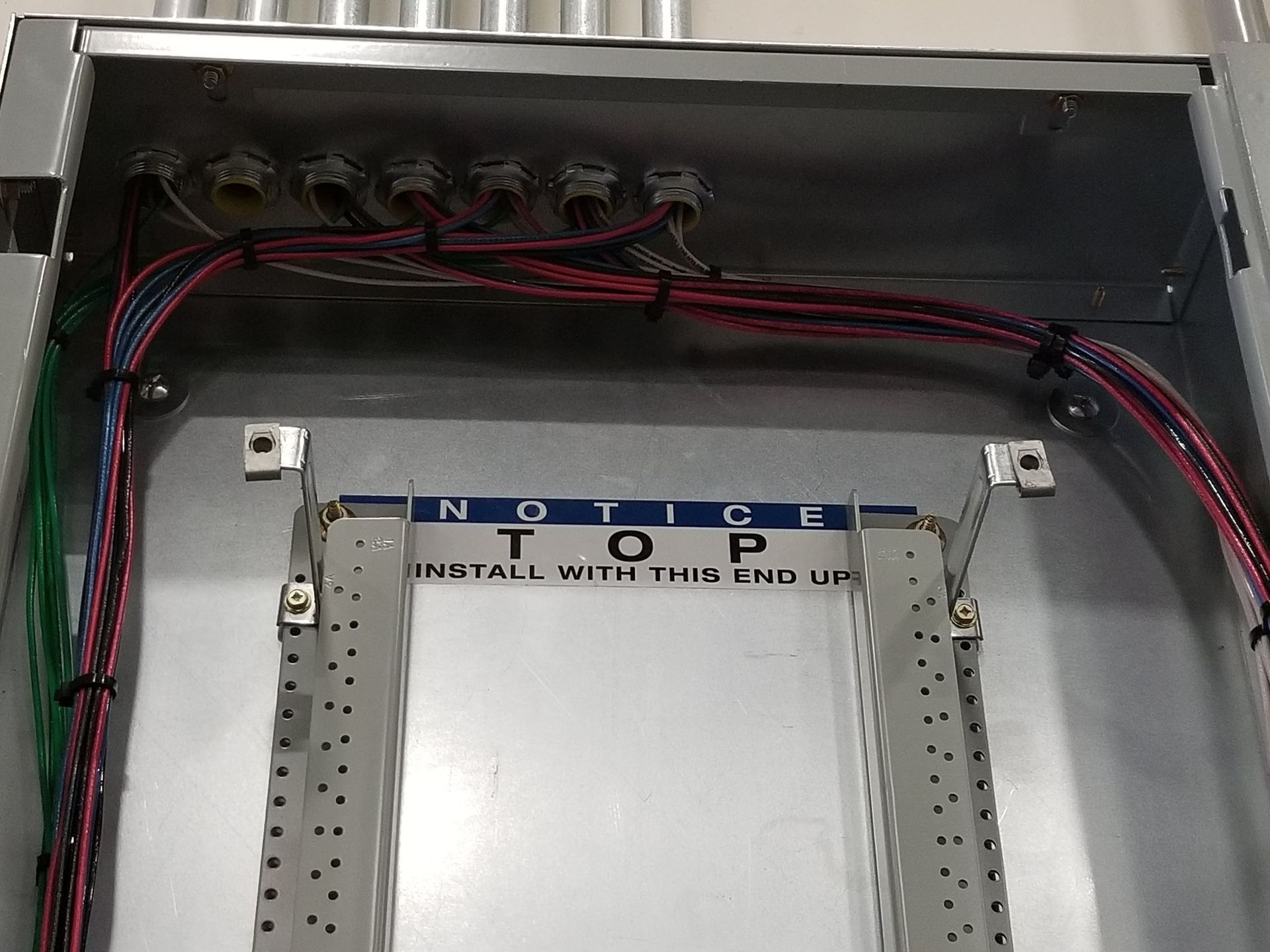 Interior view of electrical panel with wires and connectors. 