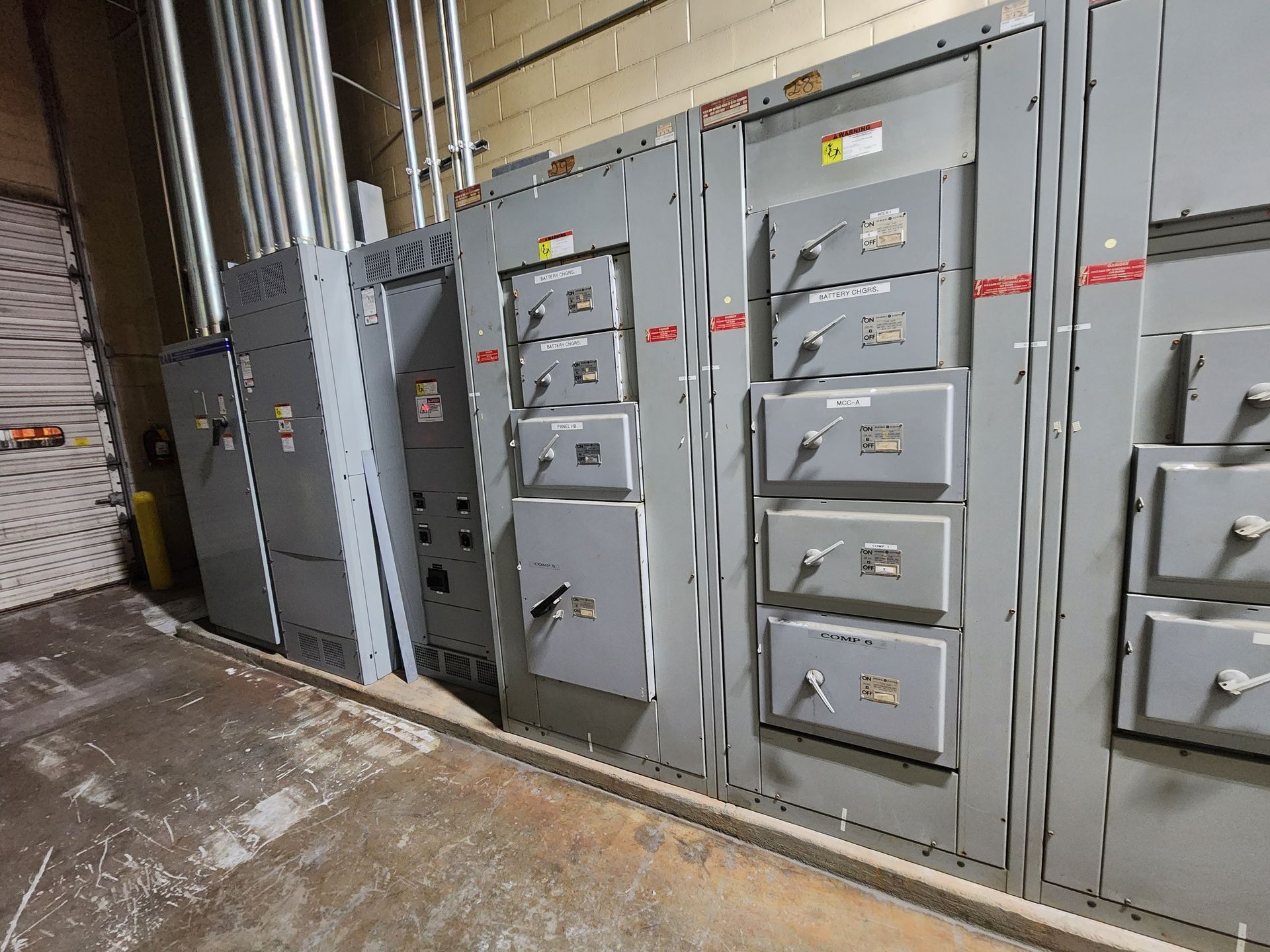 Electrical panel with multiple gray metal boxes and conduit in a commercial setting.