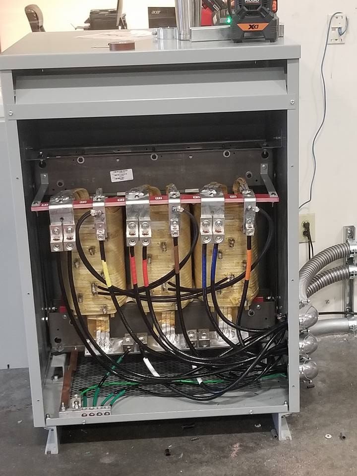 Electrical transformer cabinet with exposed wiring and components.