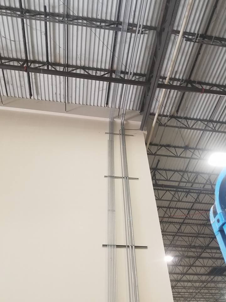 Electrical conduit runs vertically along an interior wall, up to a metal ceiling.