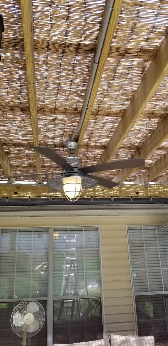 Outdoor ceiling fan with light under a covered patio.