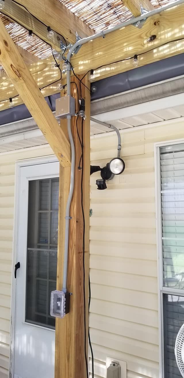 Electrical wiring on a wooden support post for outdoor lighting.