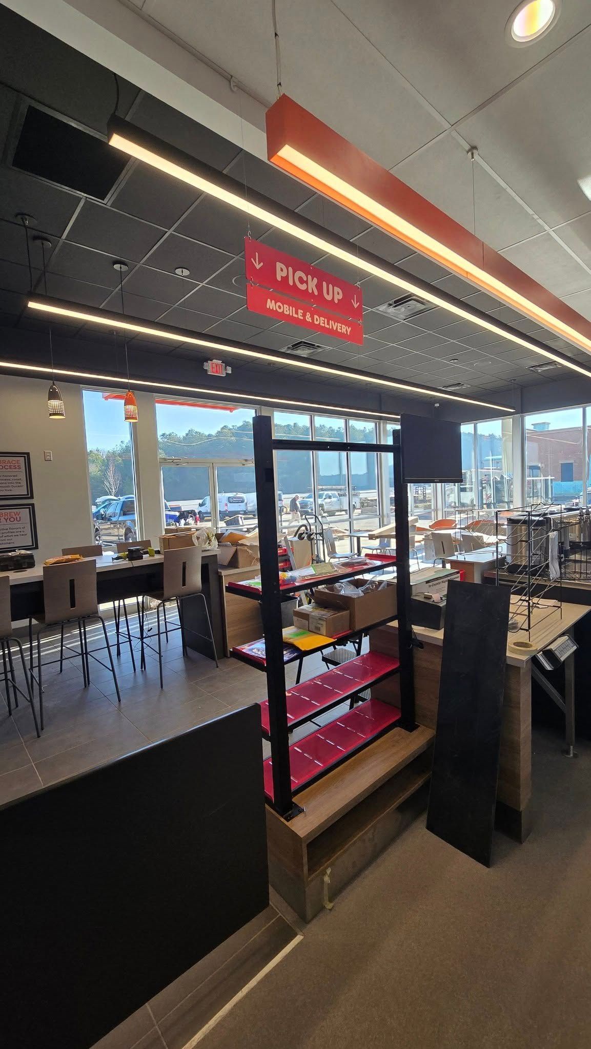 Interior view of a store with shelves and windows, illuminated by overhead lighting, featuring a “Product” sign.