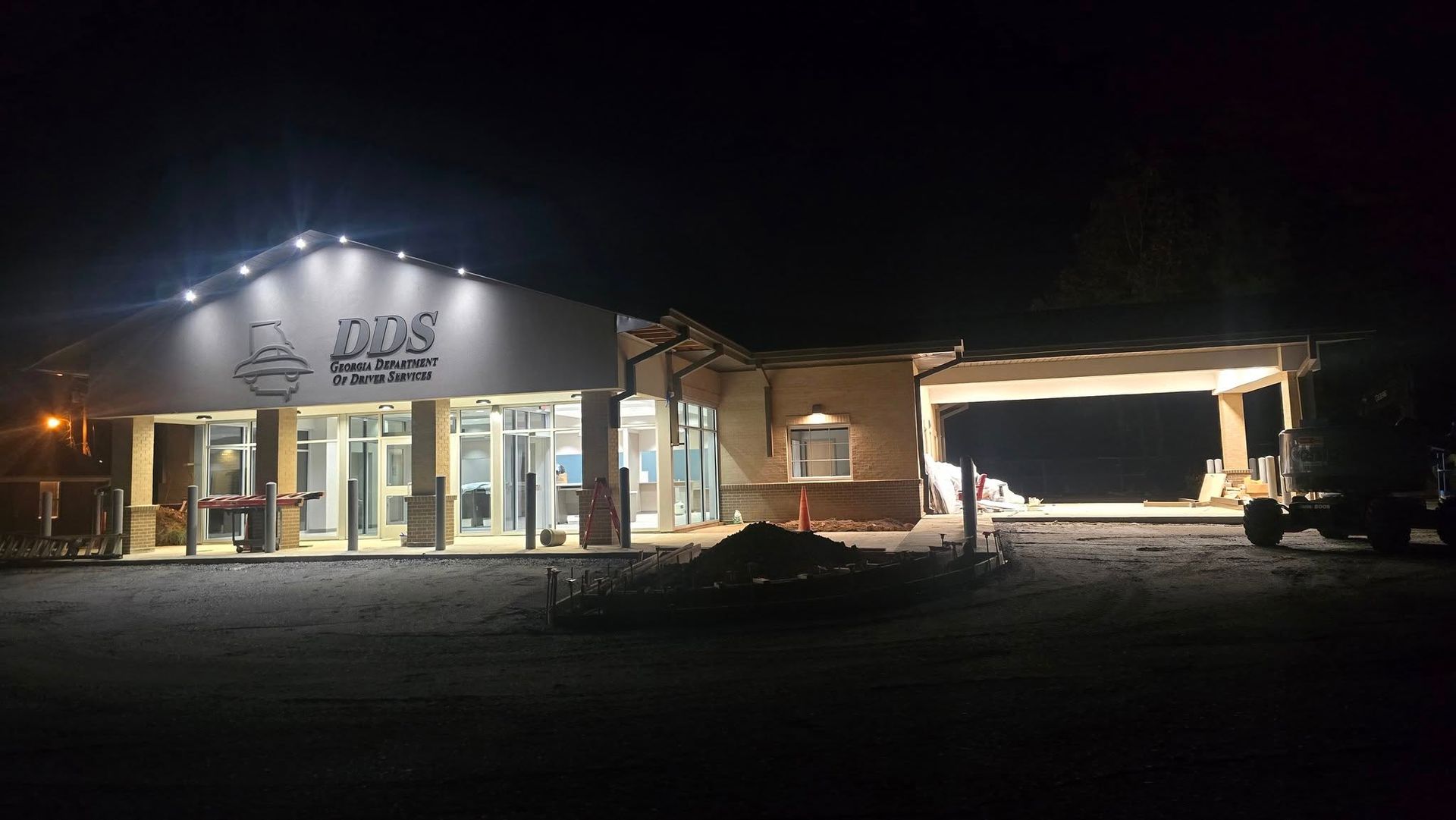 A building at night, lit by exterior lights, with the letters 