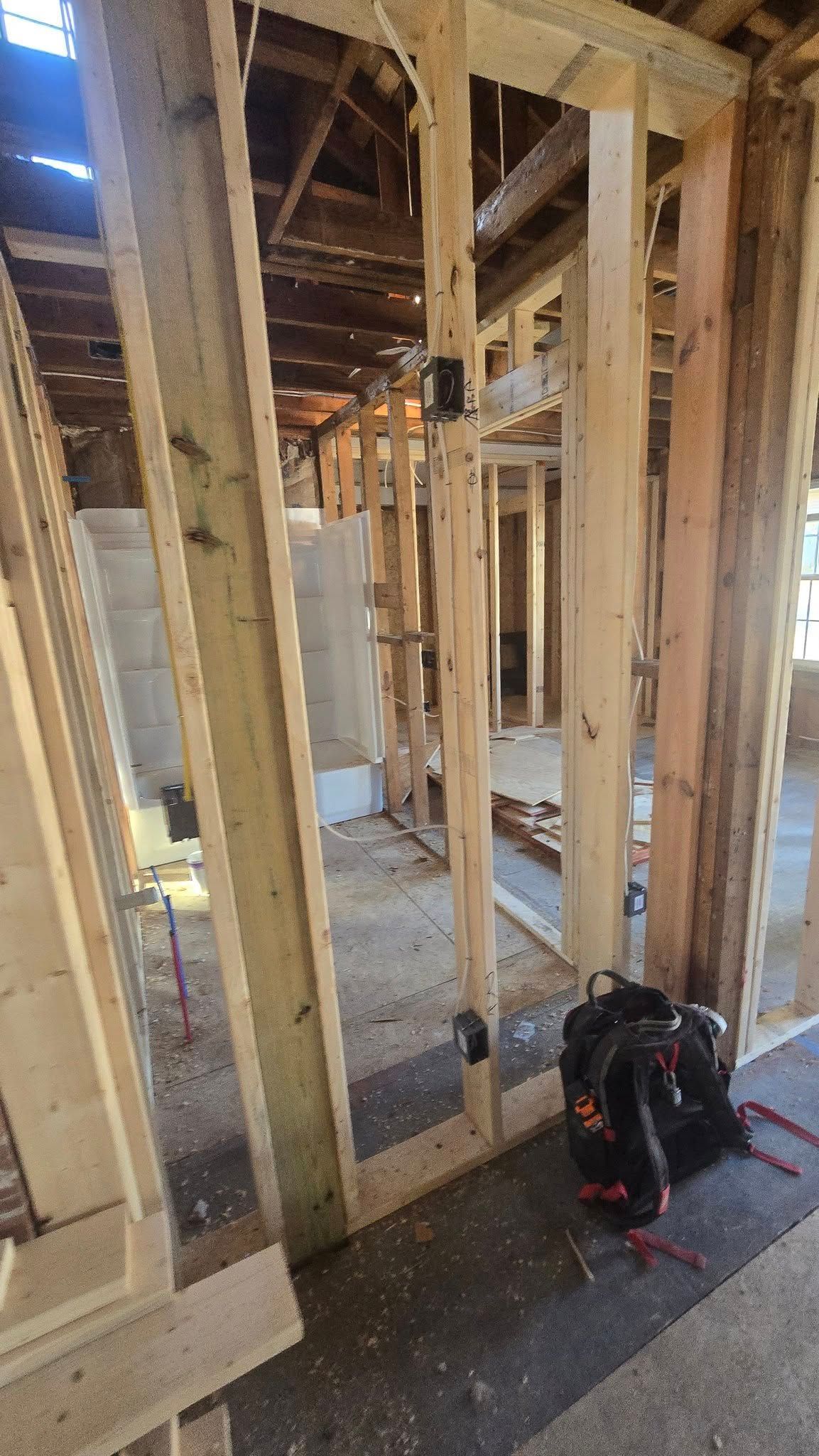 Interior view of a building under construction, showing wooden framing and exposed structure.