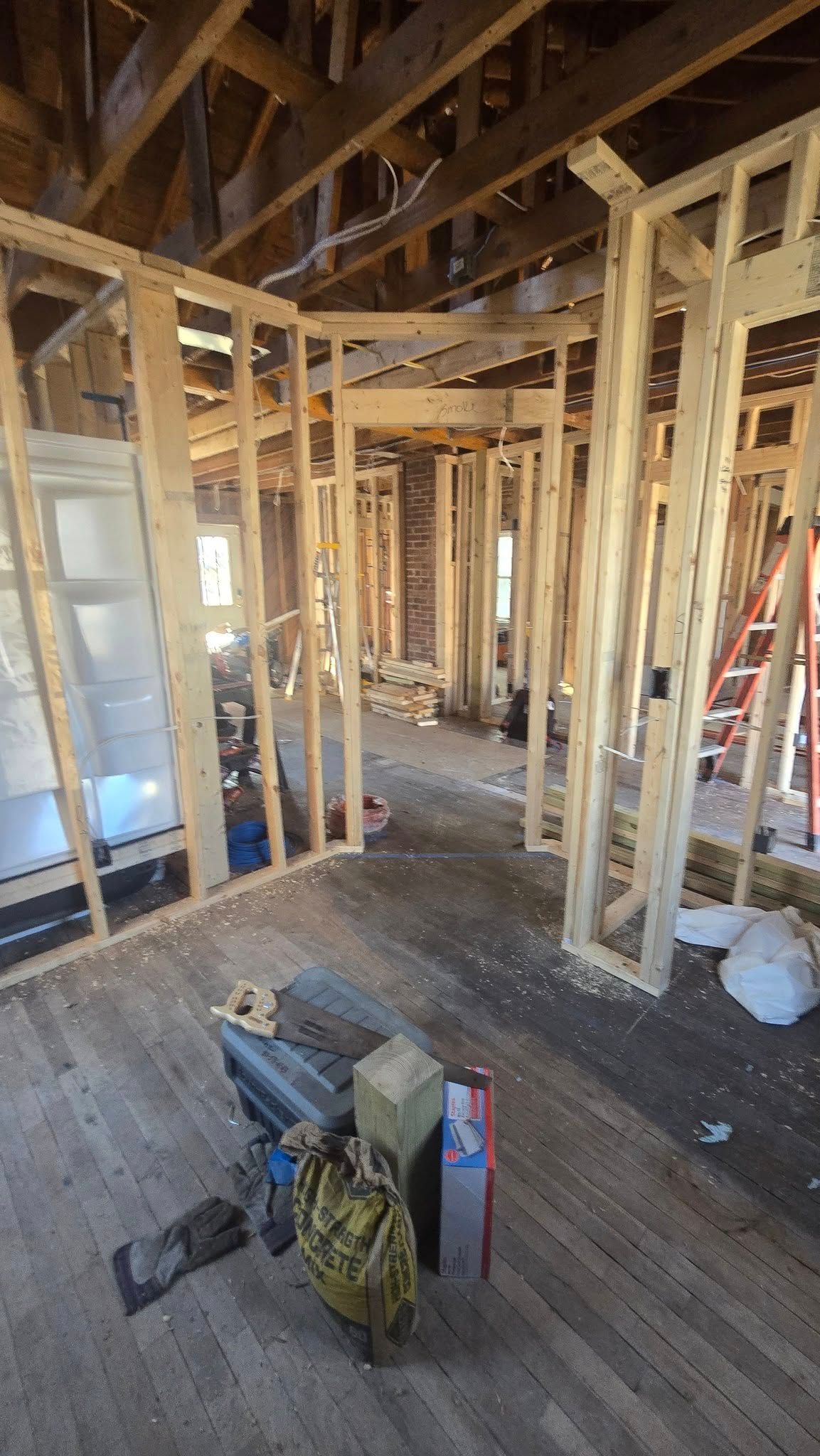 Interior framing of a house under construction; wooden studs and exposed beams.