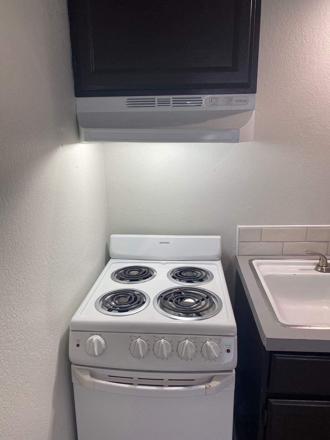 A person is working on an electrical box with a screwdriver.