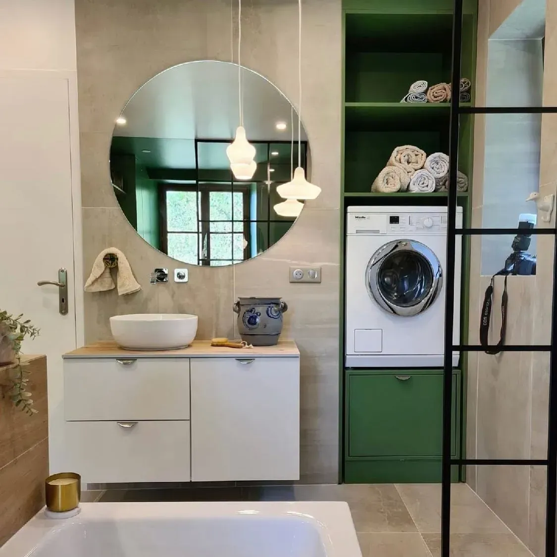 une salle de bain avec baignoire, lavabo, laveuse et sécheuse.