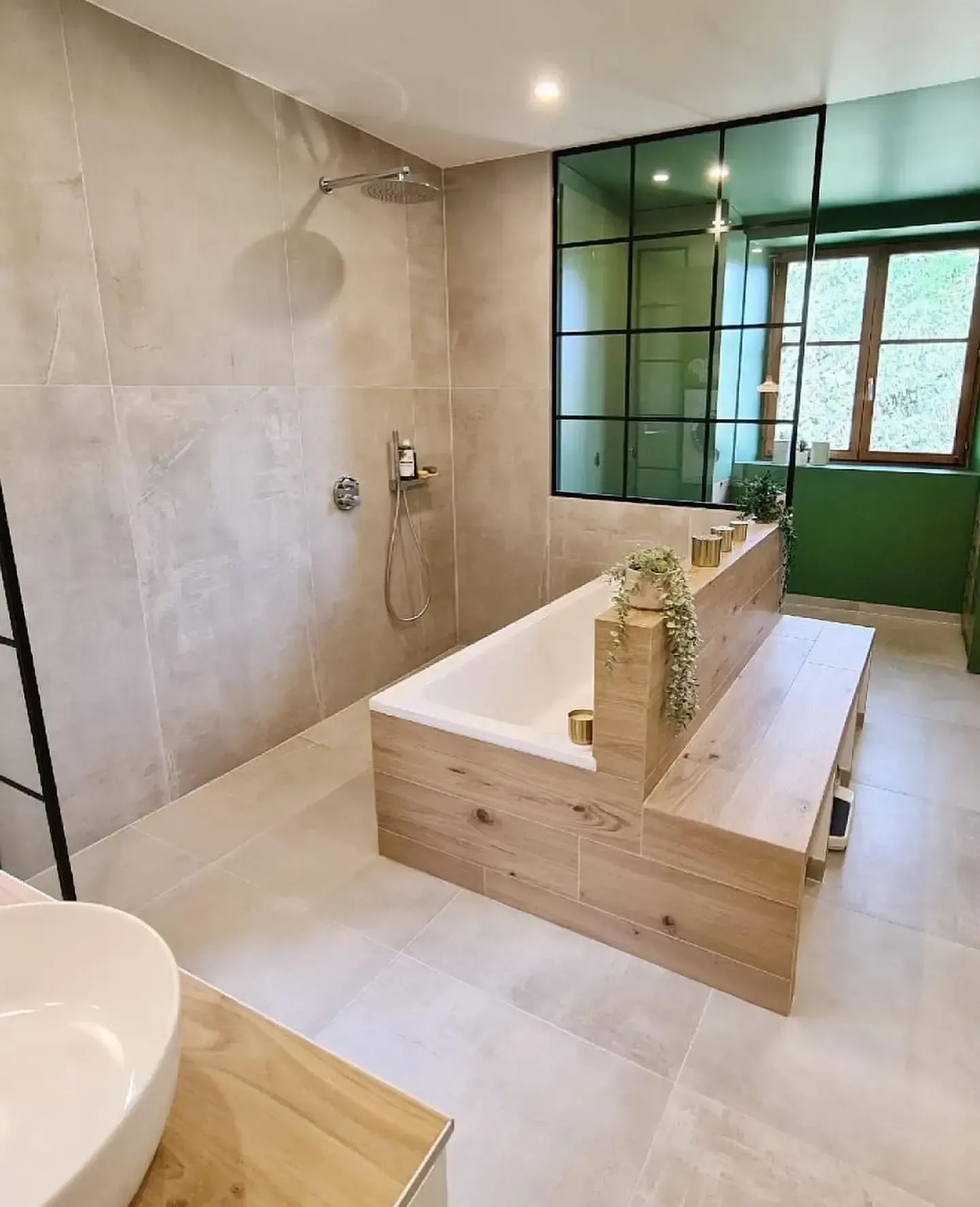 une salle de bain avec baignoire, lavabo et douche.