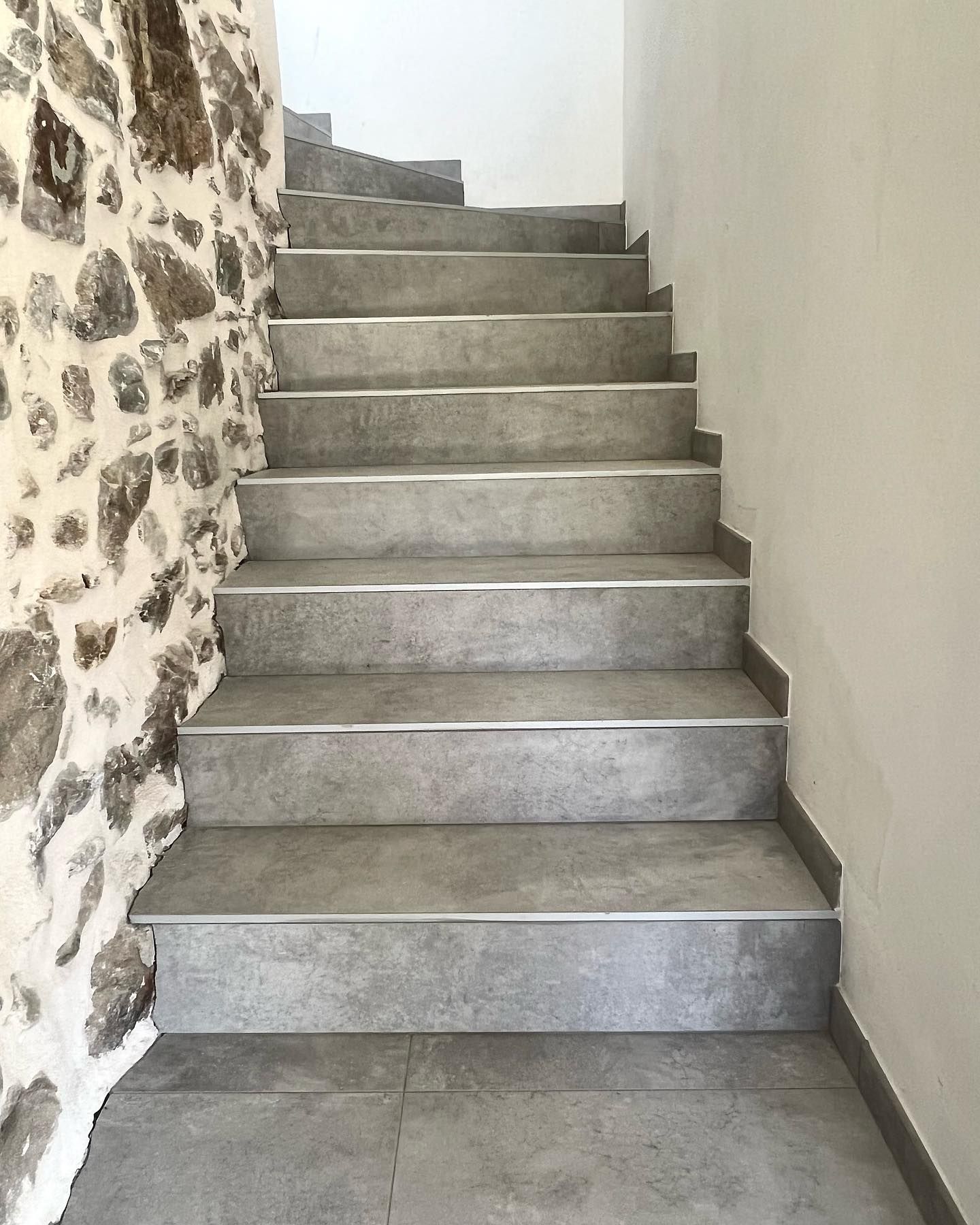 un escalier avec un mur de pierre en arrière-plan .