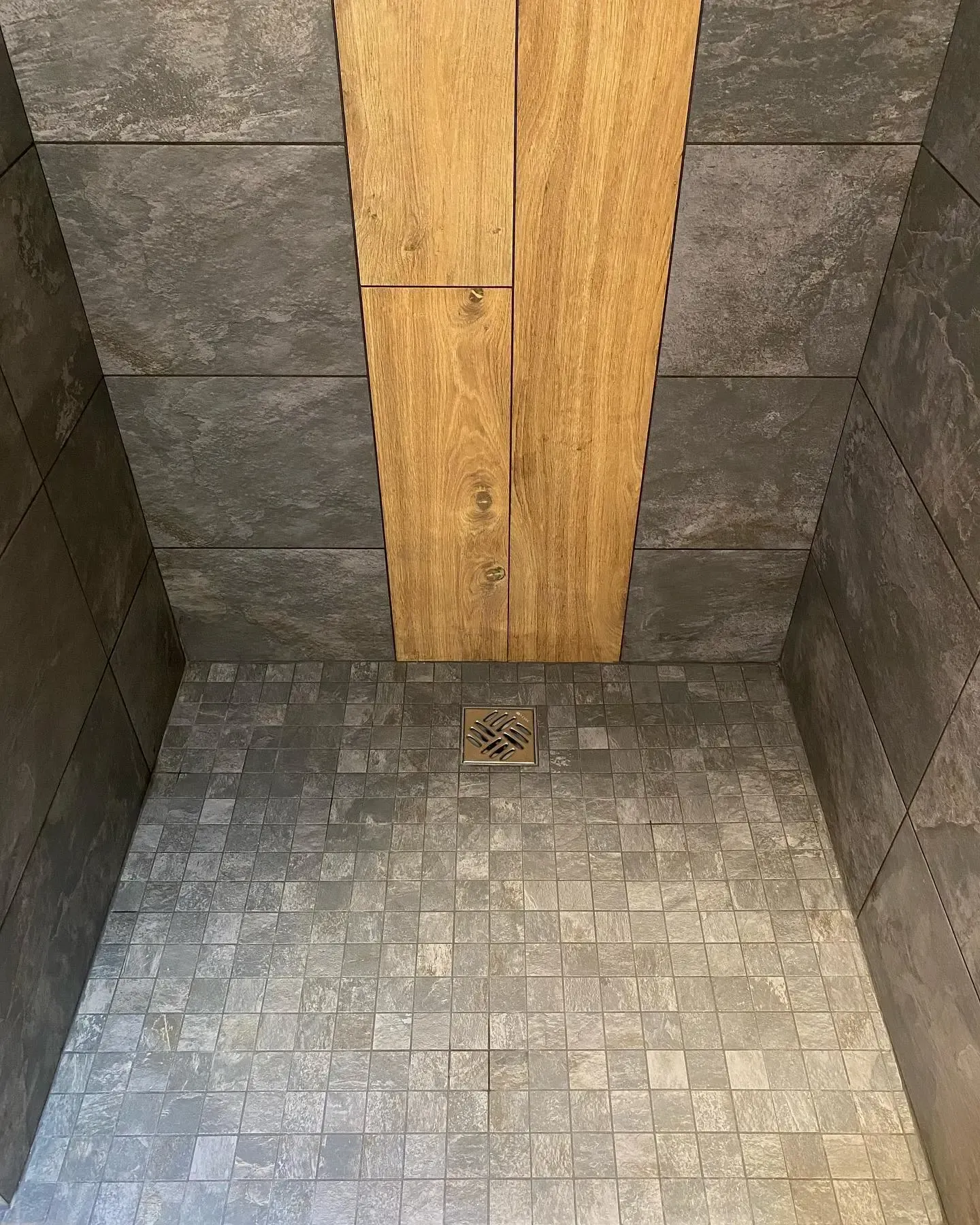 une cabine de douche avec une étagère en bois et une évacuation .