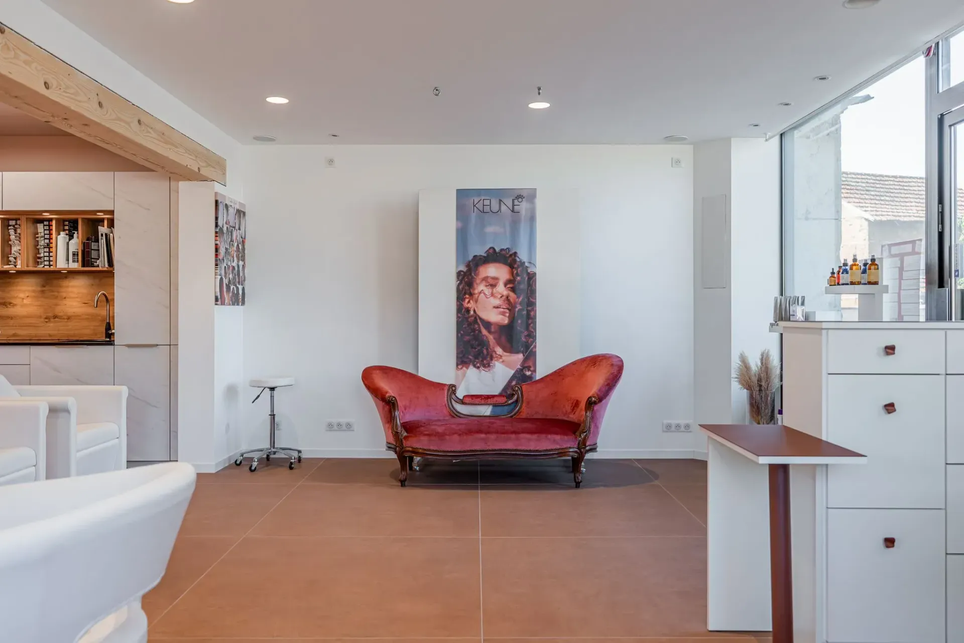 un salon avec un canapé rouge et un tableau au mur.