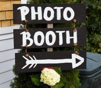 Outdoor sign for a photo booth at an outdoor wedding reception
