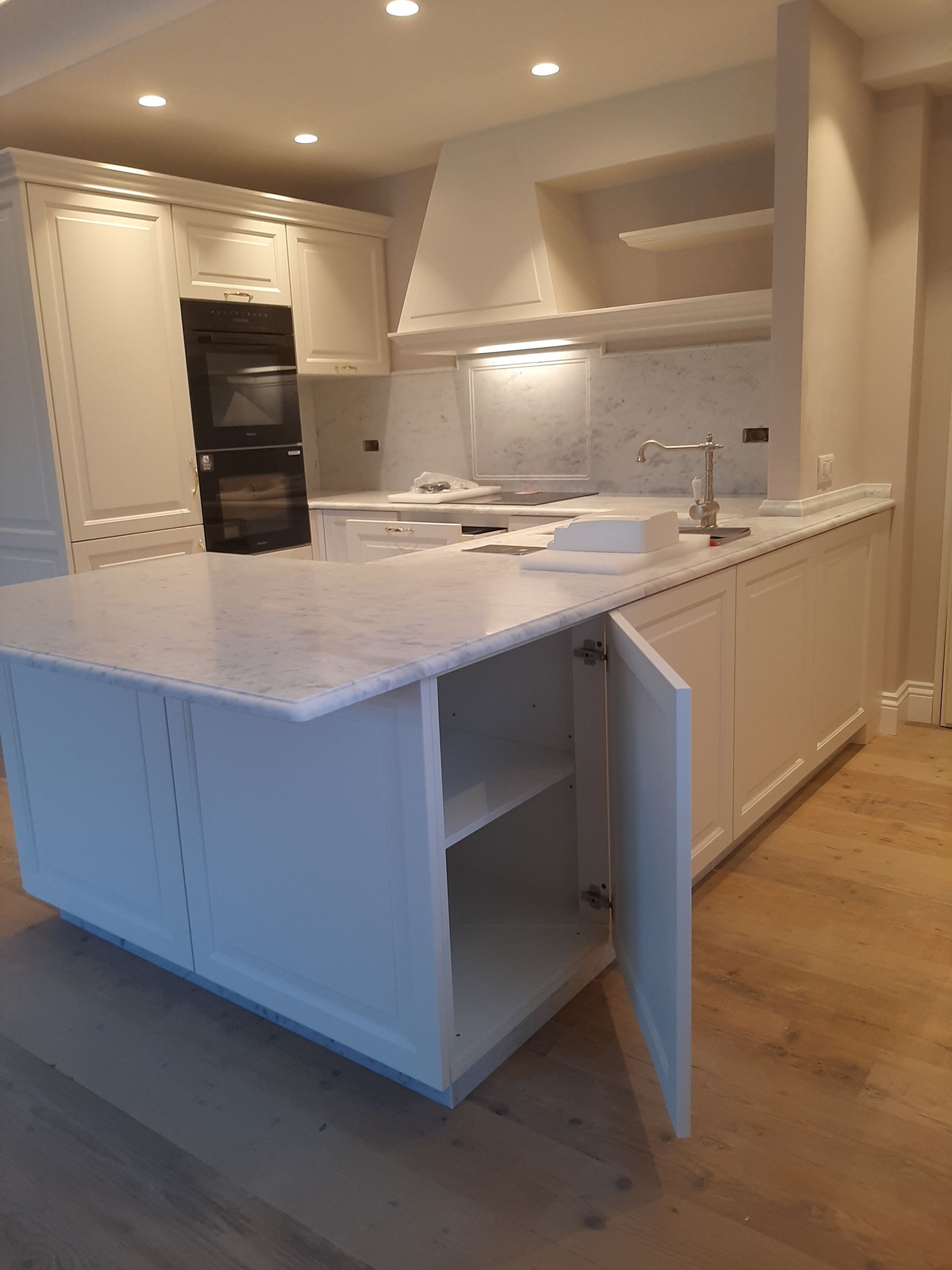 Un vaso di fiori viola è appoggiato sul bancone della cucina.