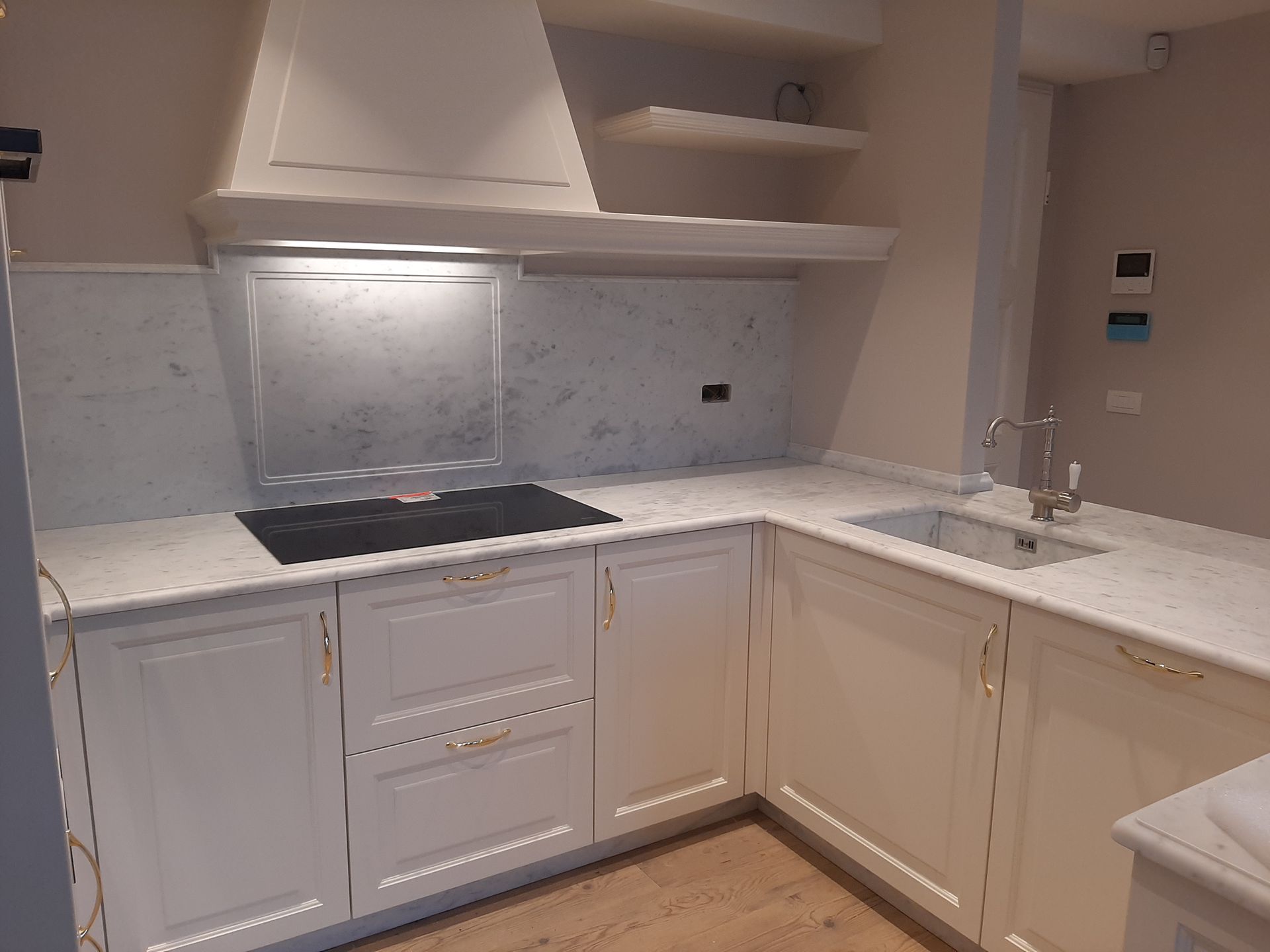 Una cucina con tavolo, sedie e una ciotola di frutta sul bancone.