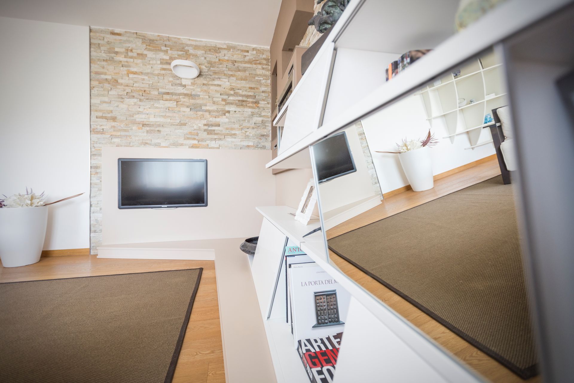 Un soggiorno con una tv a schermo piatto sul muro