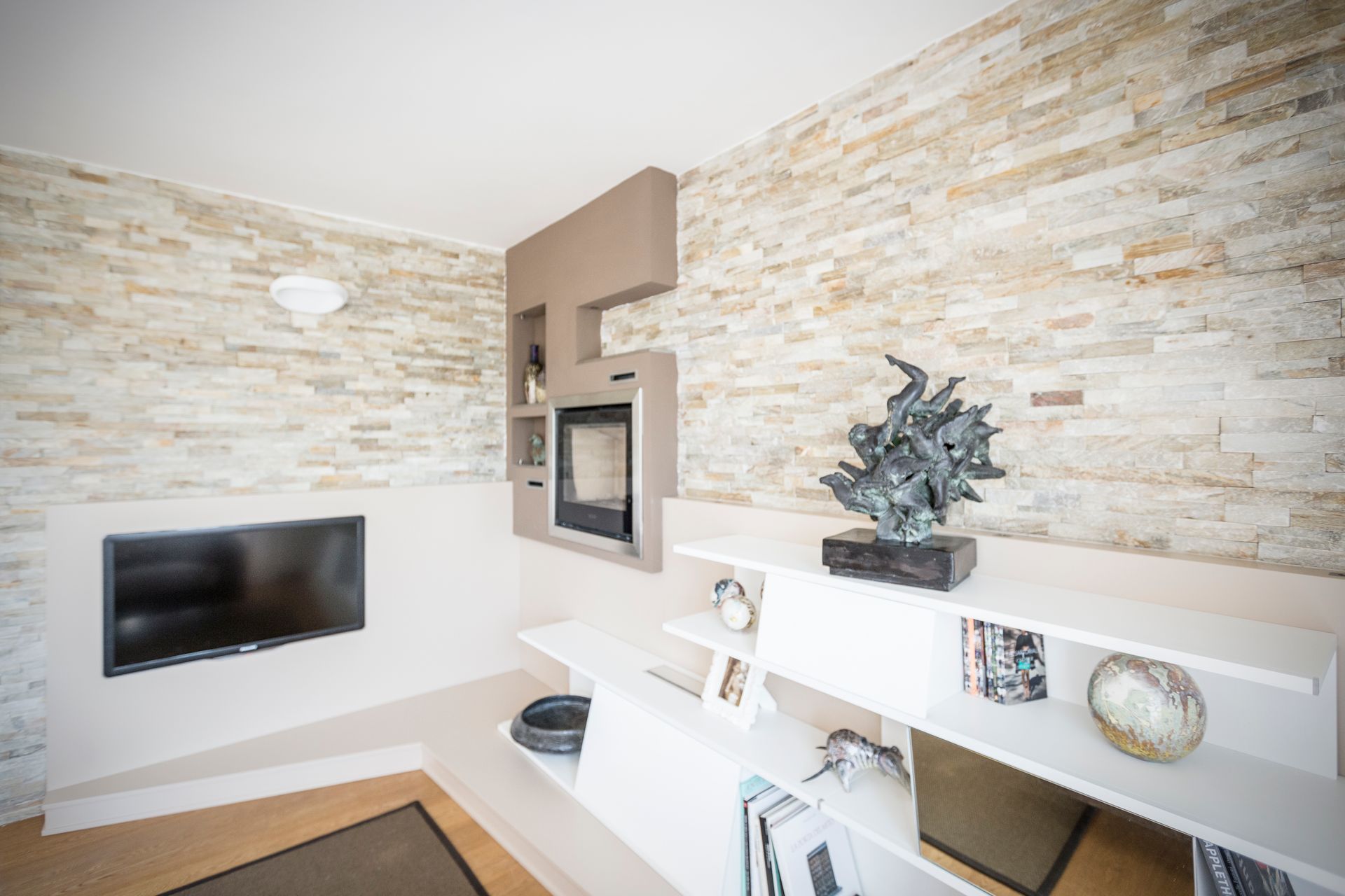 Un soggiorno con camino e tv a schermo piatto.