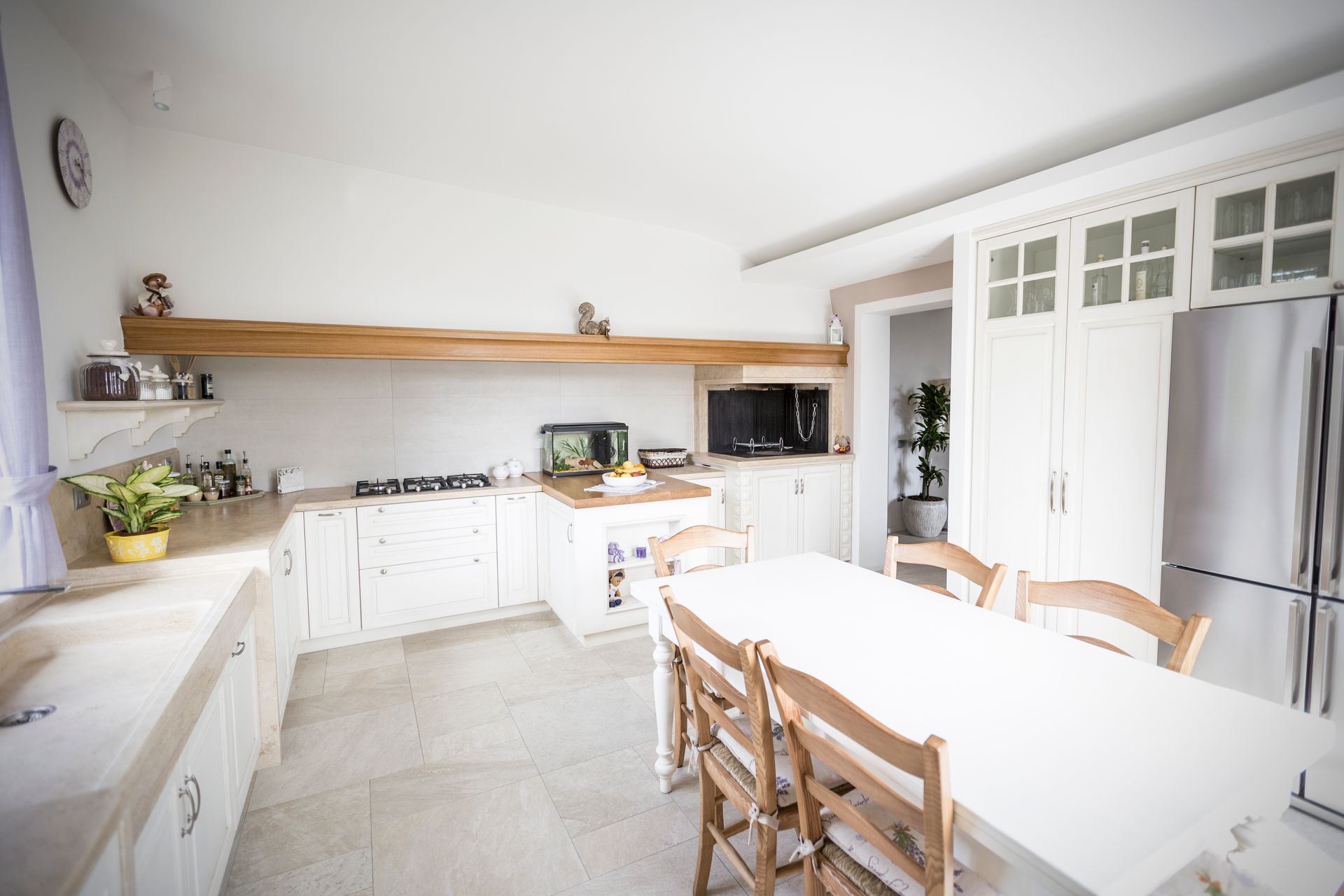 Una cucina con mobili bianchi, un tavolo e sedie.