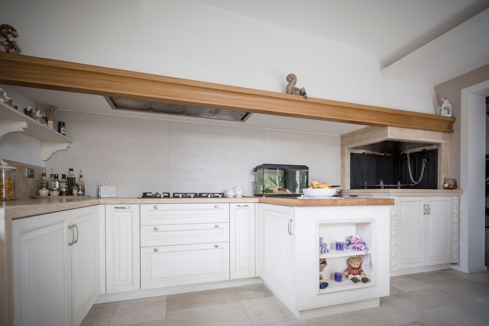 Una cucina con mobili bianchi e soffitto in legno