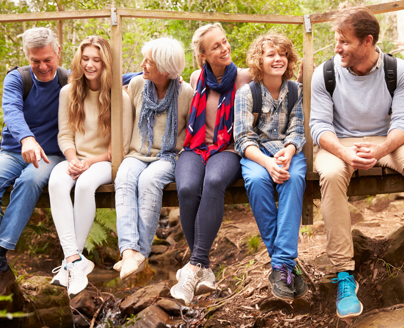 A family of various ages smiling and enjoying being outside.