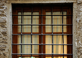 A wooden window with metal bars on it