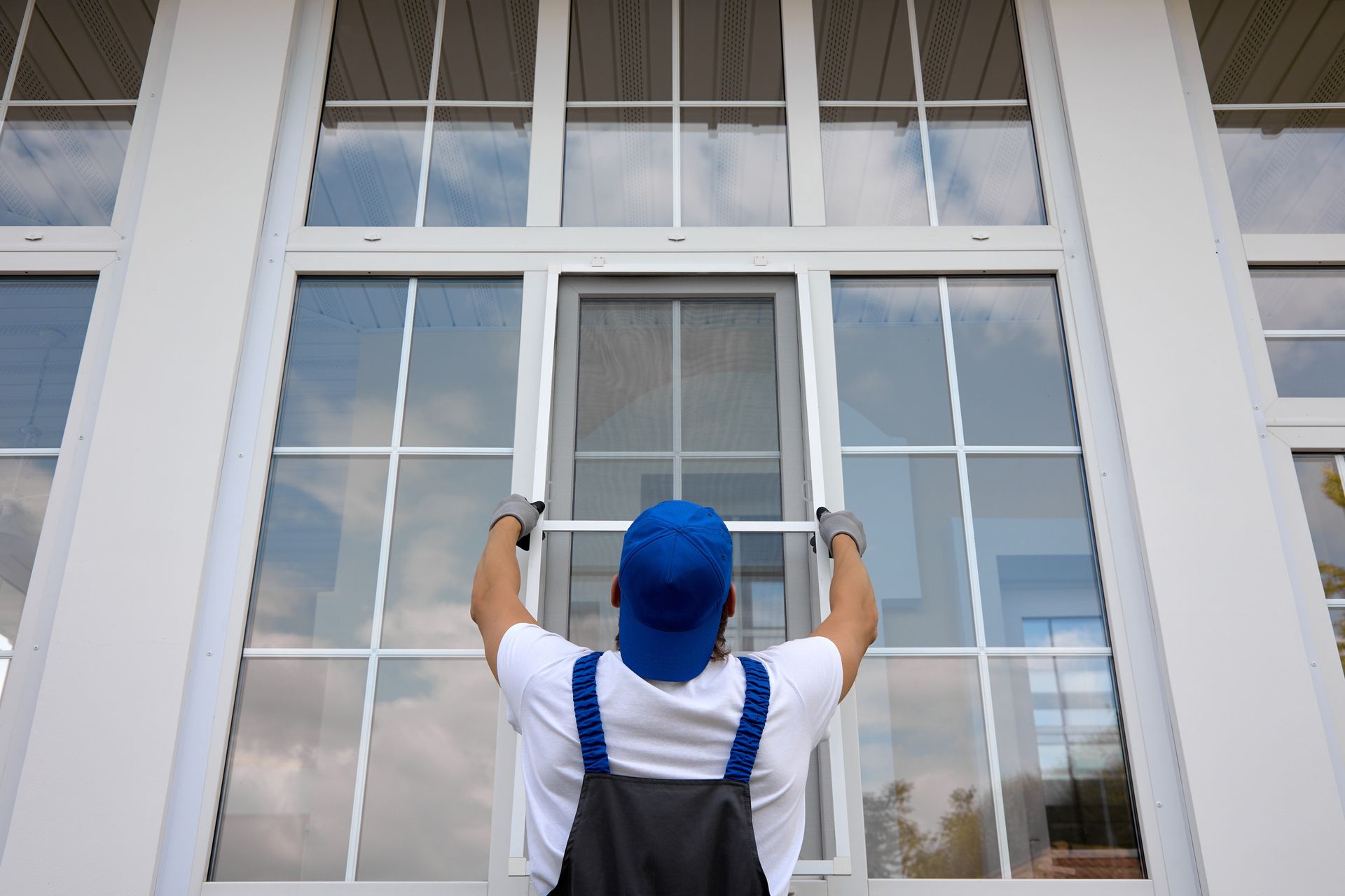 A man is installing a window in a house.