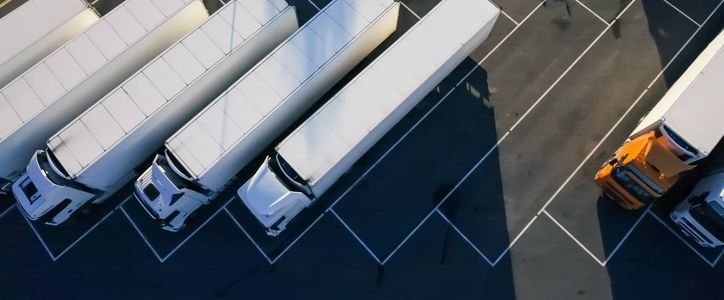 An aerial view of a row of trucks parked in a parking lot.