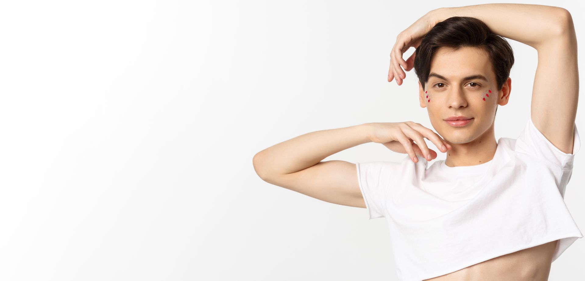 A young man is wearing a white crop top.