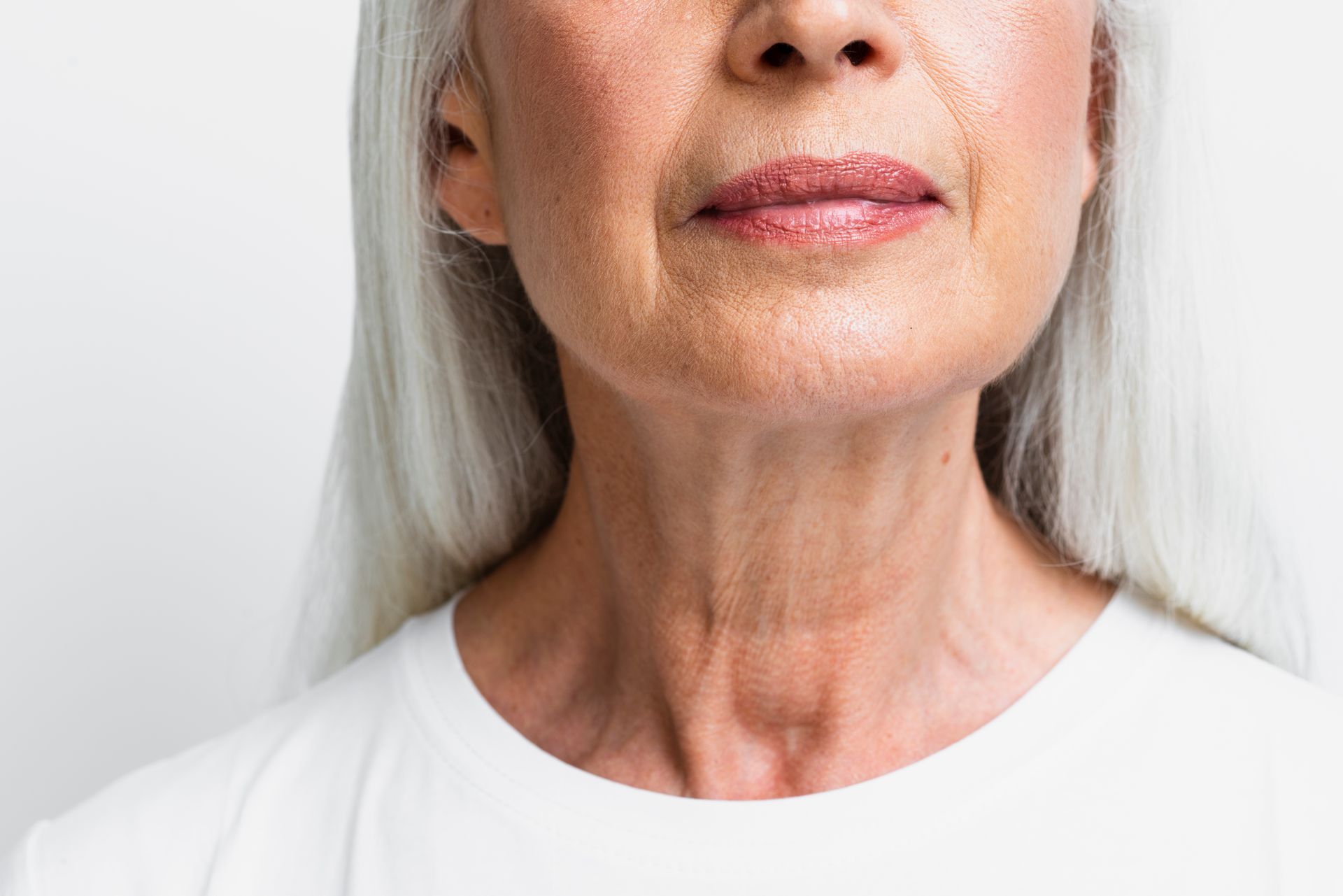 A close up of an older woman 's neck and face.