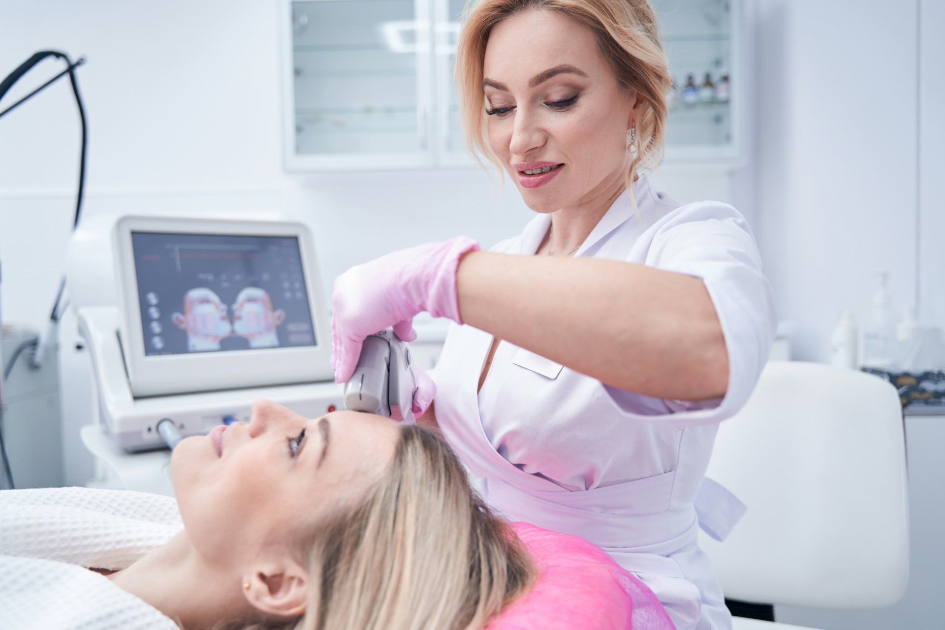 A woman is getting a treatment on her face in a beauty salon.