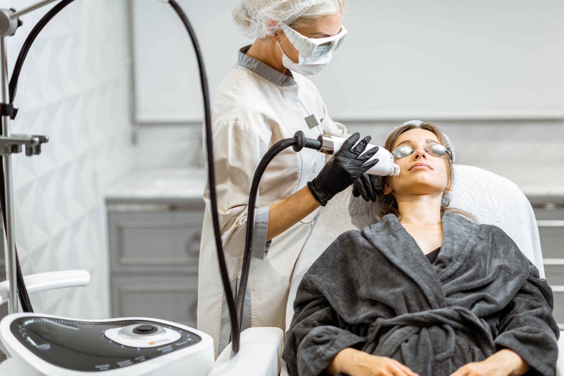 A woman is getting a laser treatment on her face.