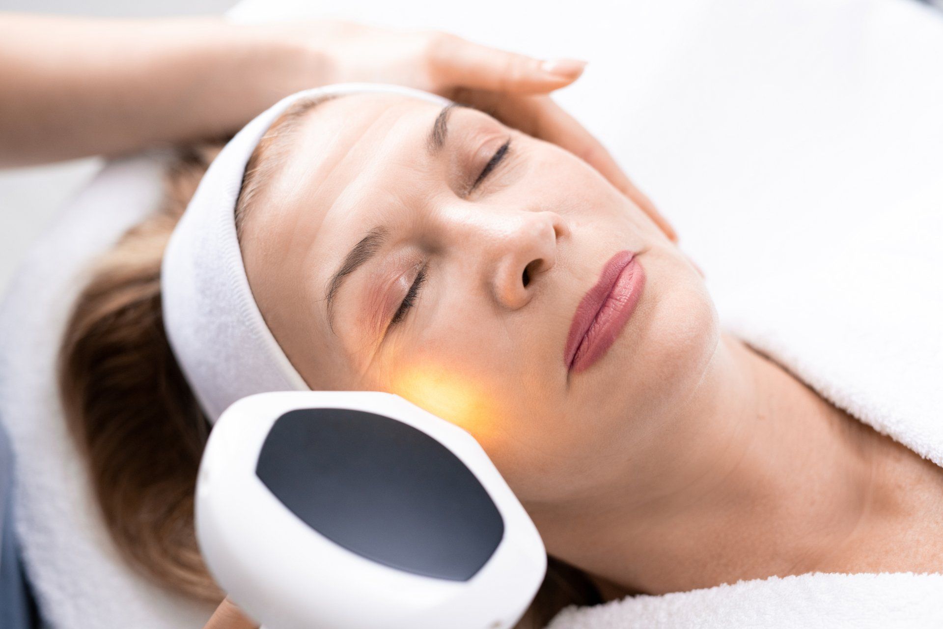 A woman is getting a laser treatment on her face.