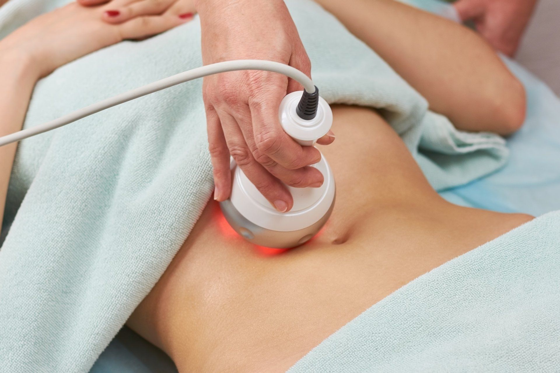 A woman is getting an ultrasound treatment on her stomach.