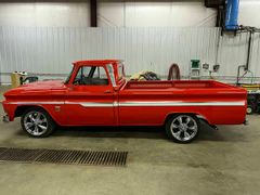 A red pickup truck is parked in a garage.