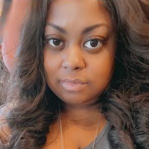 A close up of a woman 's face with long hair and a necklace.