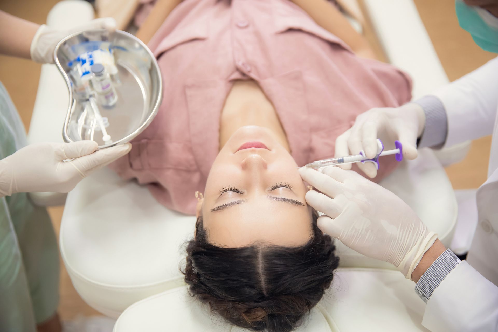 A man with a beard is getting a botox injection in his face.