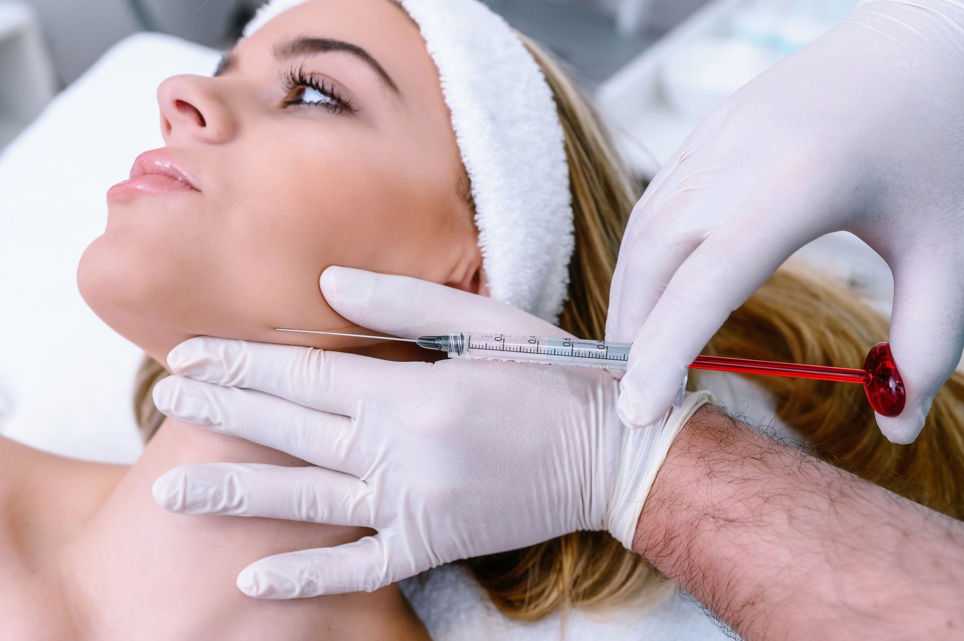 A man with a beard is getting a botox injection in his face.