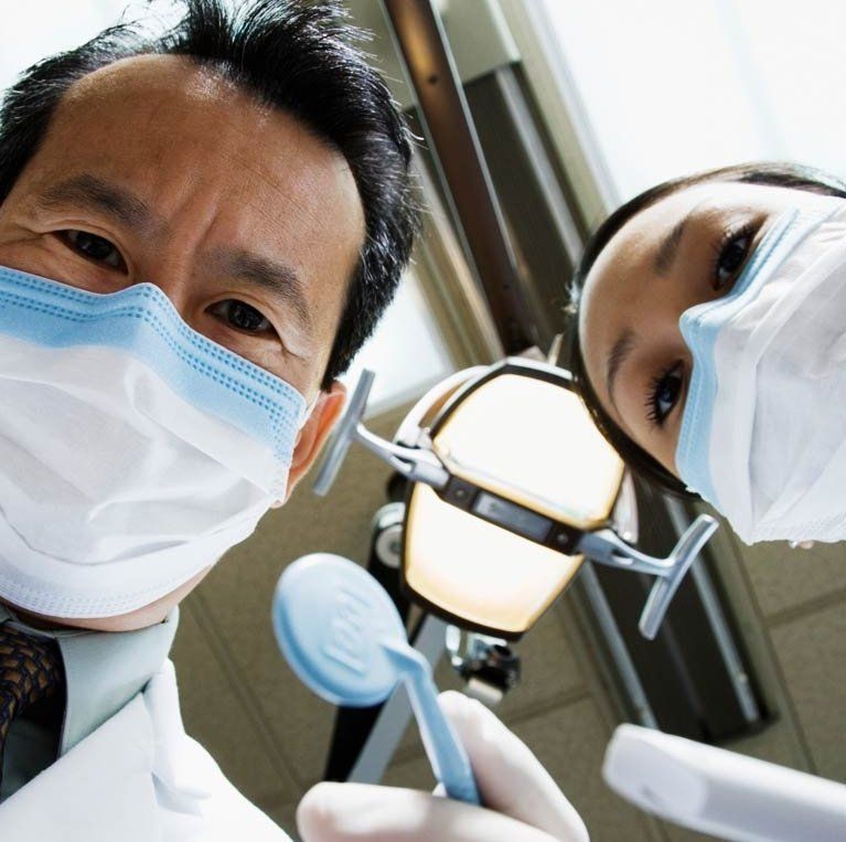 A woman is getting her face examined by a doctor wearing gloves.