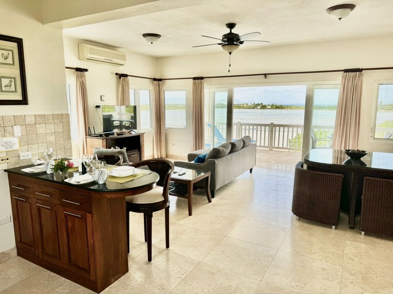 Open-concept living space with kitchen island, living room with water view, and dining area.