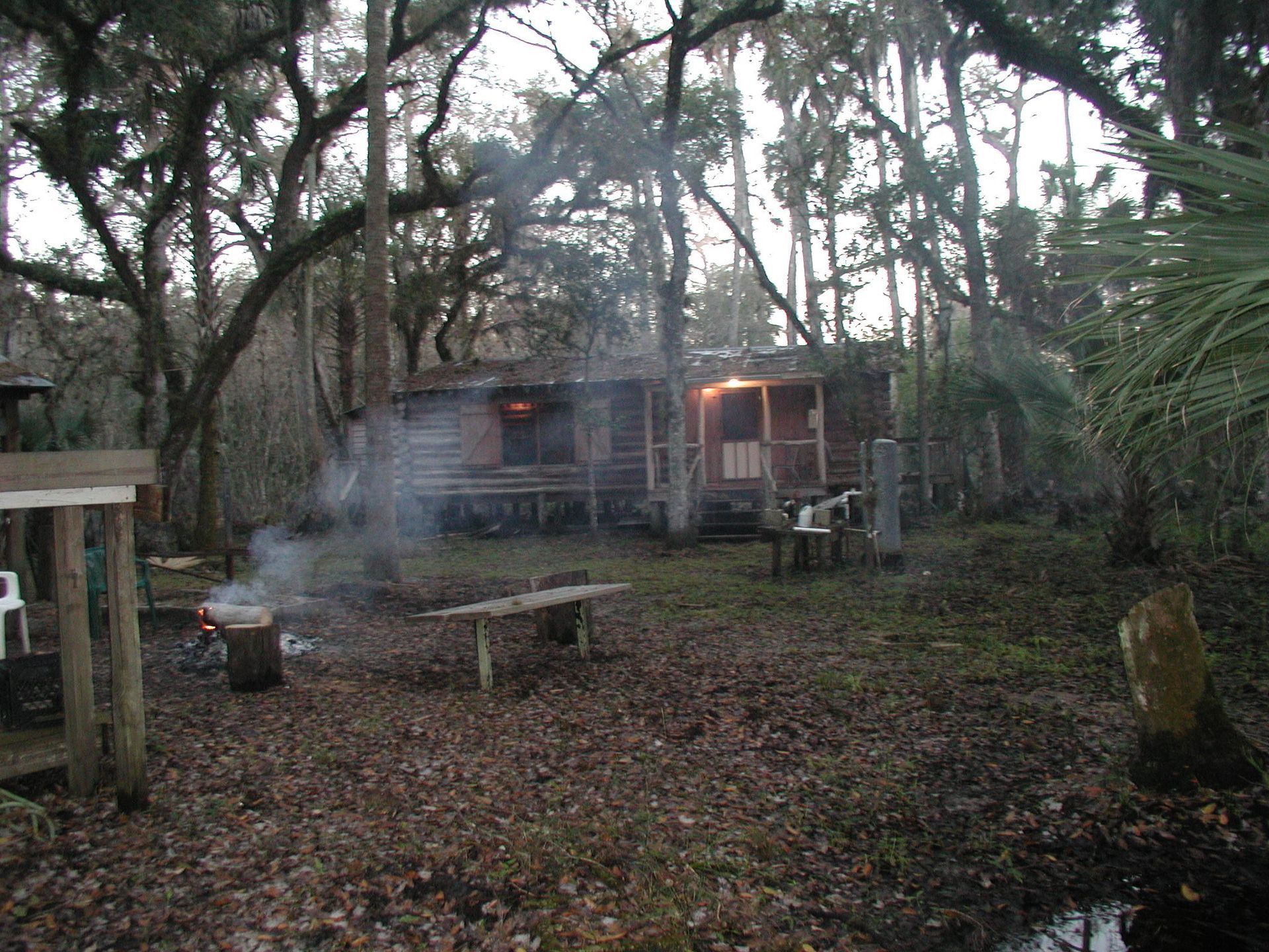 A cabin in the woods with smoke coming out of it