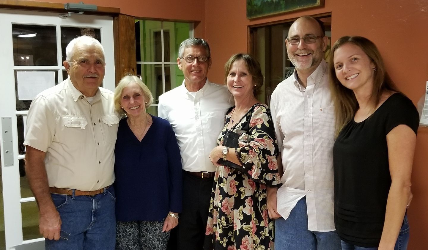 A group of people are posing for a picture together in a room.